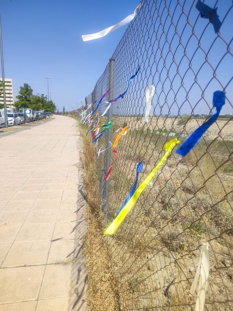 Valla de la parcela S-9 cubierta de lazos de colores
